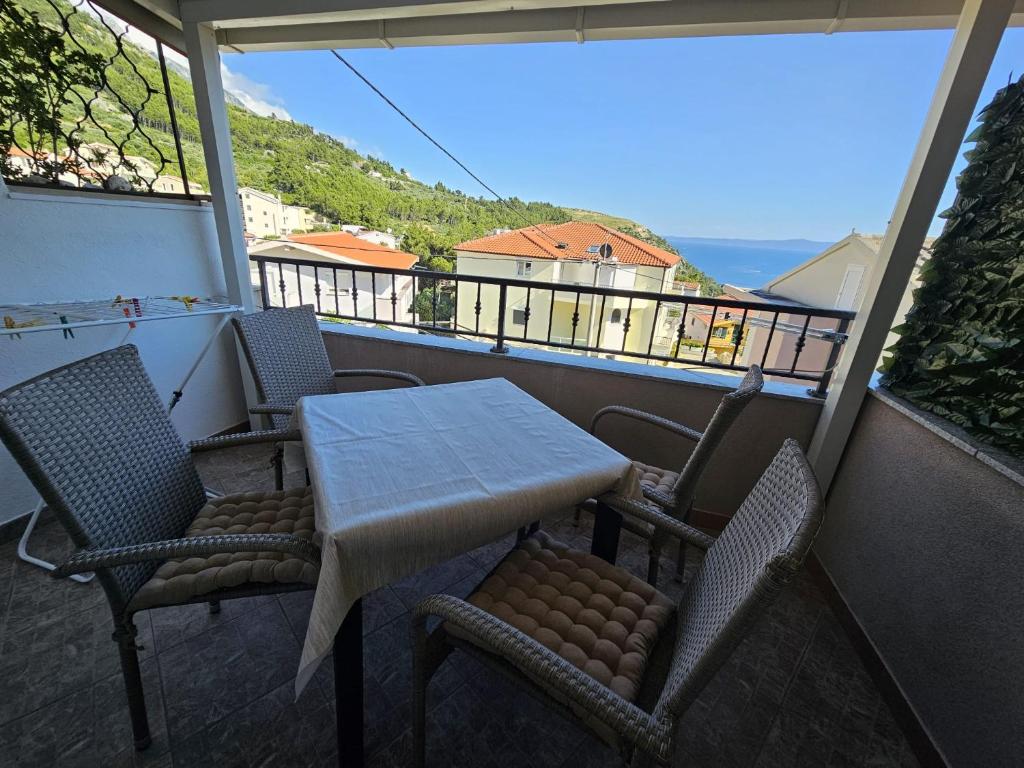 una mesa y sillas en un balcón con vistas en Studios Dolček, en Krvavica