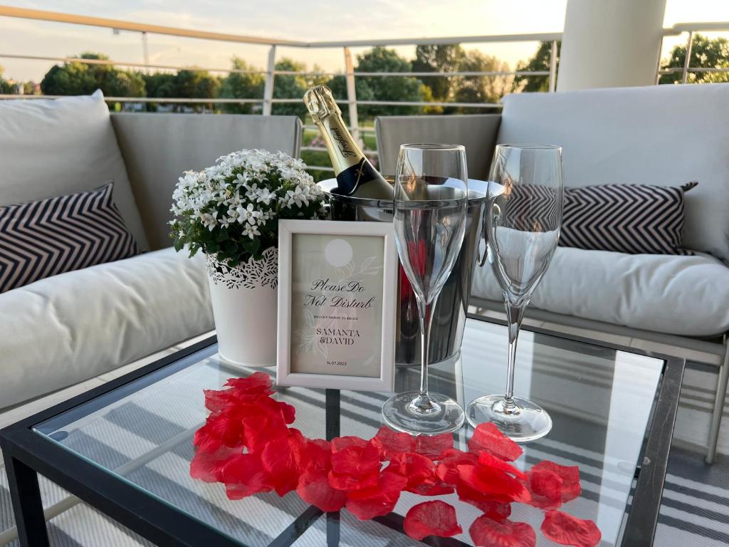 a glass coffee table with wine glasses and red flowers at PAGANINI suits and apartments in Sirmione