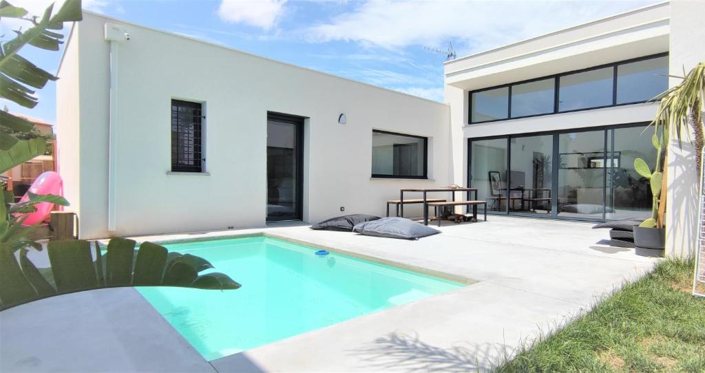 una piscina nel cortile di una casa di Oasis Blue Perpignan Canet a Perpignano