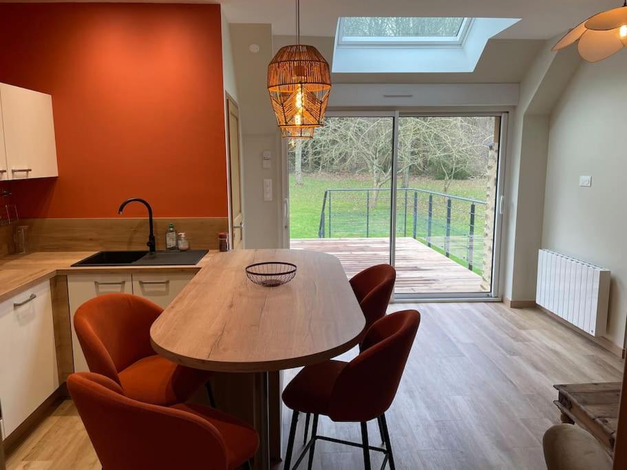 une cuisine avec une table et des chaises en bois ainsi qu'une fenêtre dans l'établissement Gîte 5 personnes le bas du bois, à Moitron-sur-Sarthe