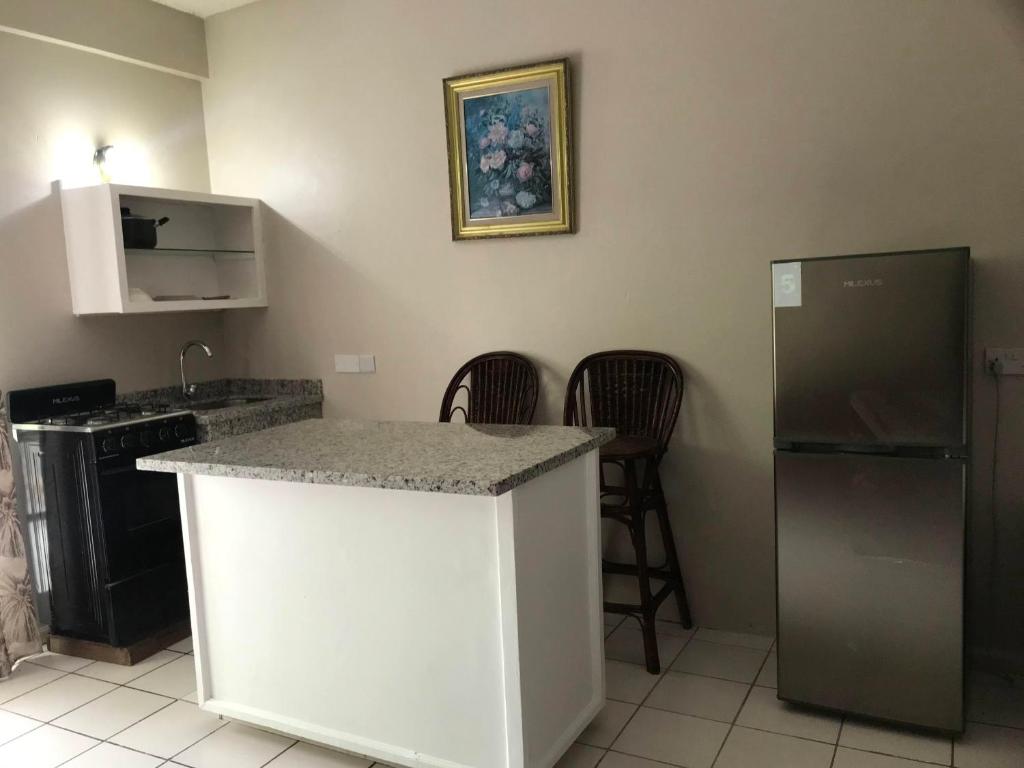 eine Küche mit einer Arbeitsplatte und einem Kühlschrank in der Unterkunft Bay Heights Escape in Gros Islet