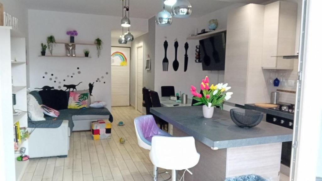 een keuken en een woonkamer met een bank en een tafel bij Pomezia centro in Pomezia