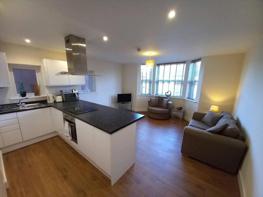 een keuken en een woonkamer met een bank en een aanrecht bij Spacious 2 double bed apartment - Free Parking - Central Beeston location in Nottingham