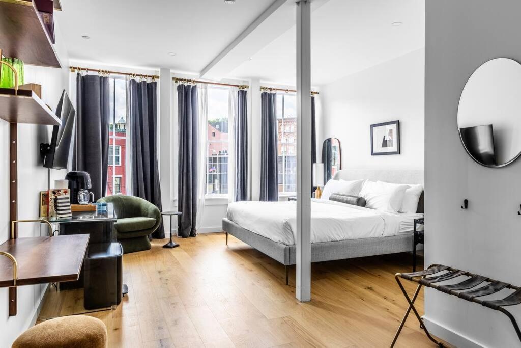 a white bedroom with a bed and a desk and a couch at The Phenix Historic DTWN Hotel, King Bed, Pickering Square View, Room # 301 in Bangor