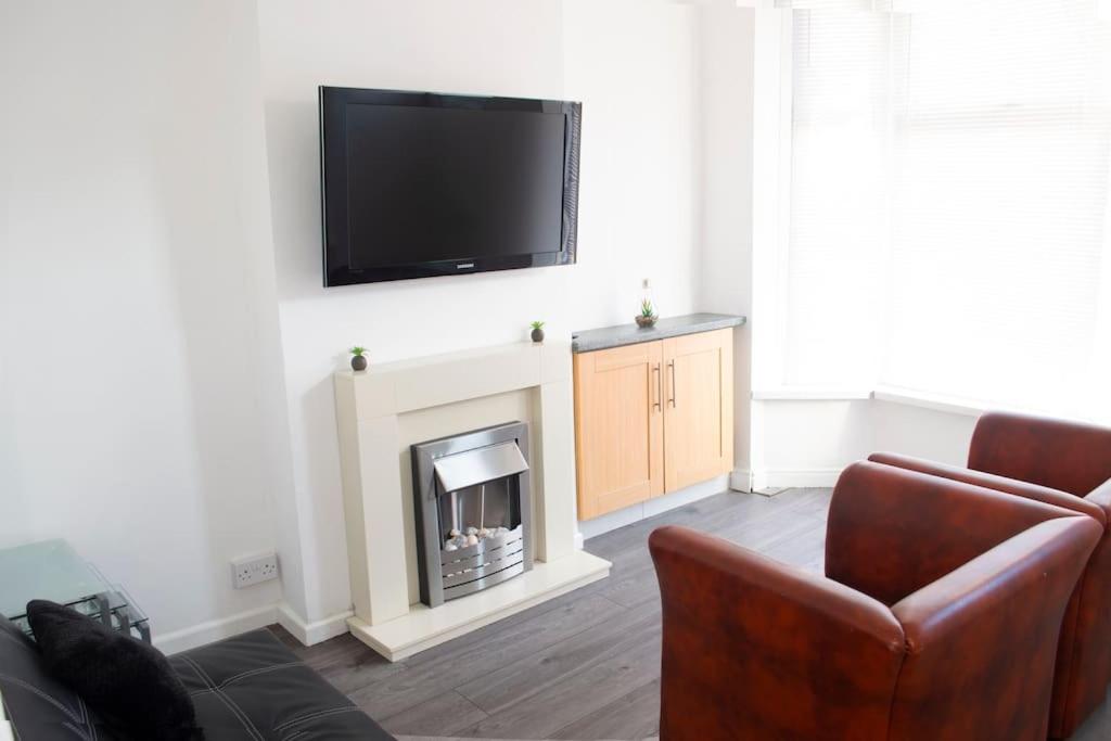 uma sala de estar com lareira e uma televisão de ecrã plano em Heartlands House, BullRing, Blues Ground, NEC, BHX em Birmingham