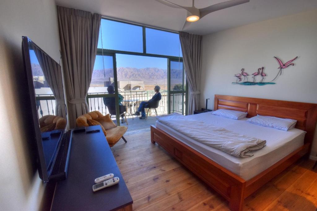 a bedroom with a bed and a large window at Desert view studio in Beʼer Ora