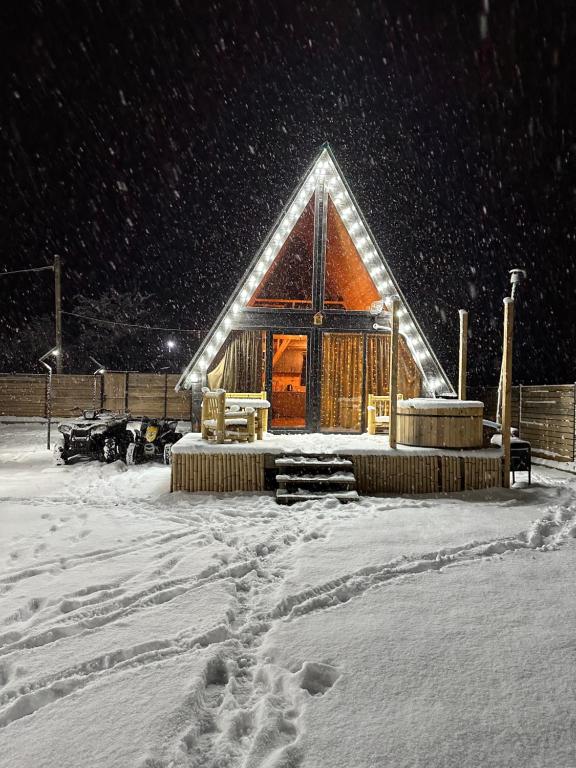 una cabaña de madera en la nieve por la noche en Borjomi Story, en Borjomi