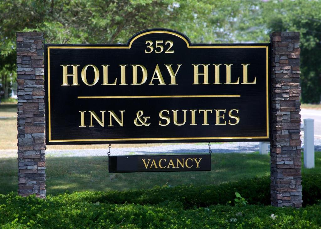 a sign for a holiday inn inn and suites at Holiday Hill Inn & Suites in Dennis Port