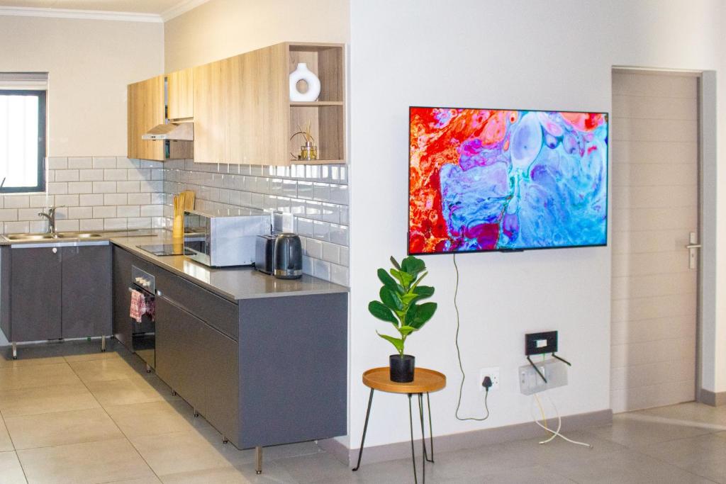 a kitchen with a painting hanging on a wall at 16 Elizabeth Place - Luxury Apartments, Free Wi-Fi in Midrand
