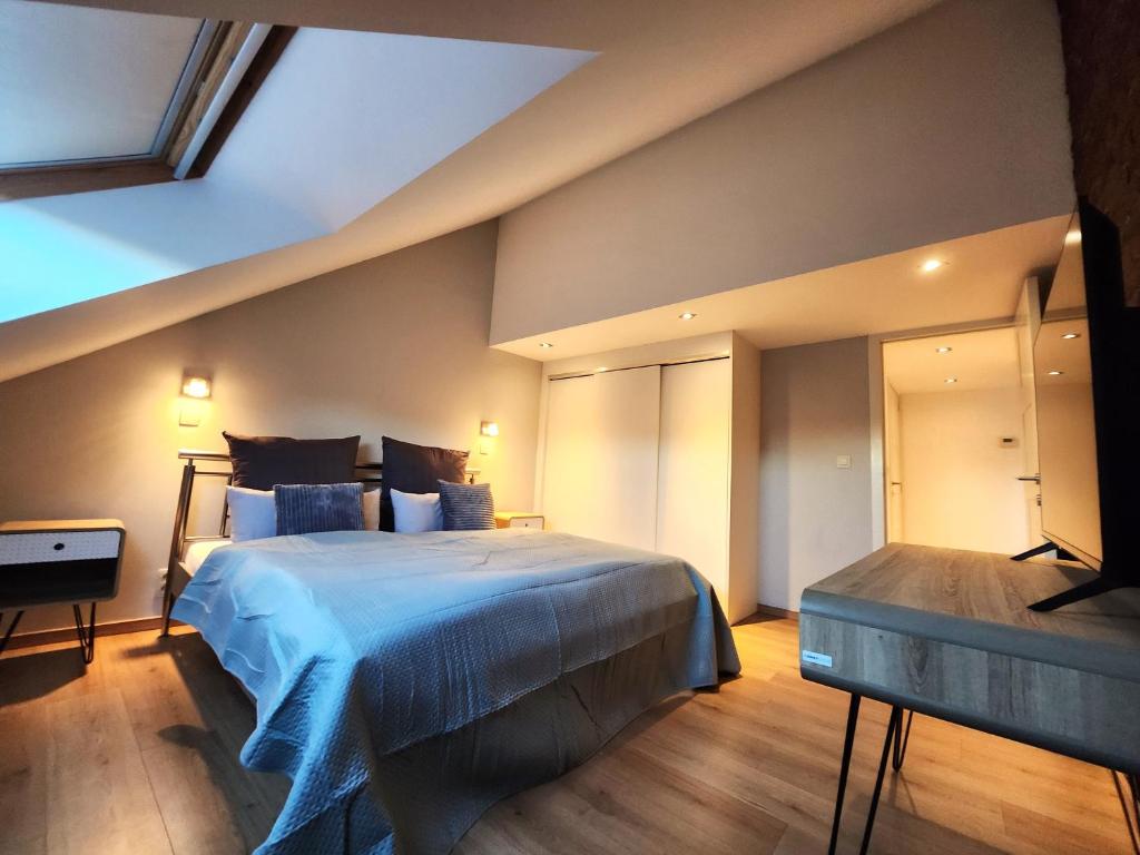 ein Schlafzimmer mit einem großen Bett mit einer blauen Decke in der Unterkunft Appart4you in Namur