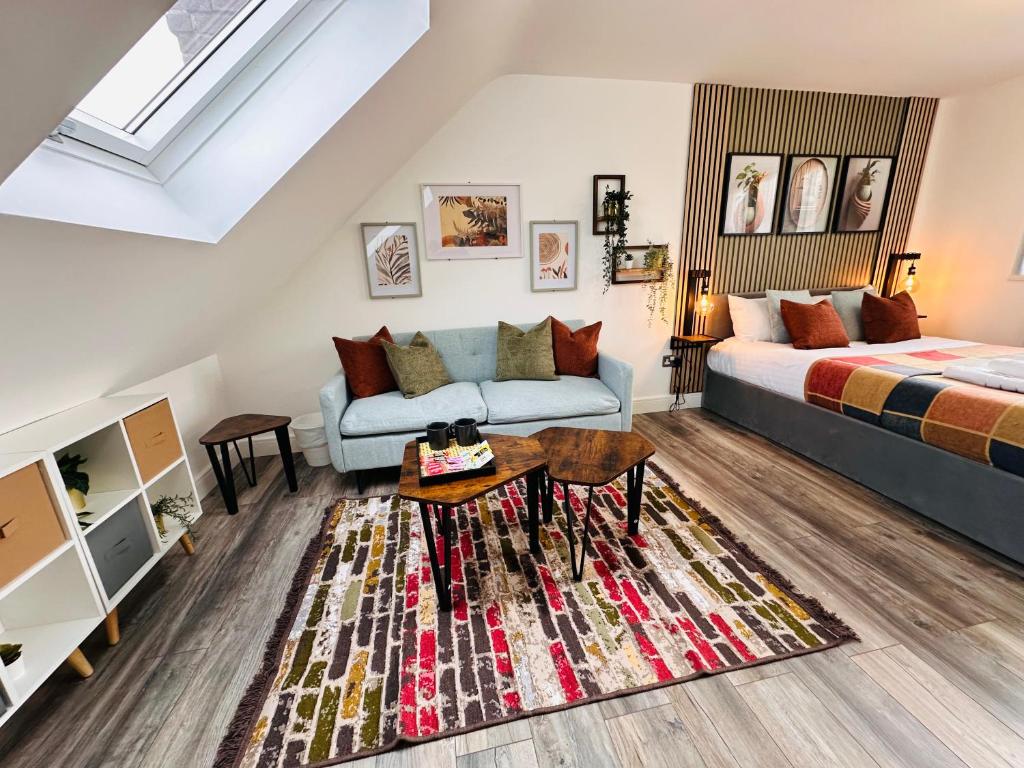een woonkamer met een bed en een bank bij R5 - Private Studio self contained En-suite Room in Newly renovated house in Birmingham B62 in Quinton