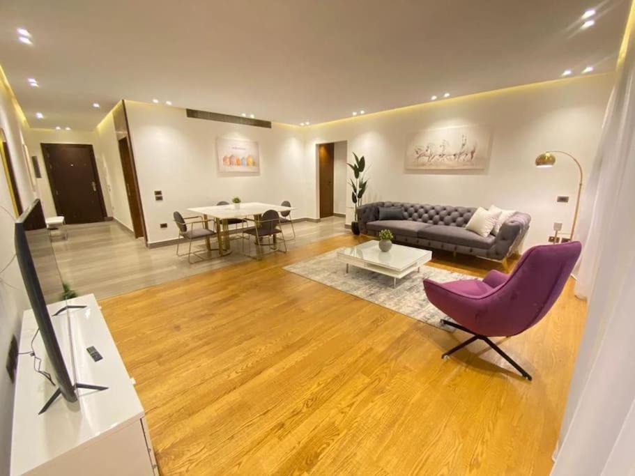 un soggiorno con un divano e un tavolo di Luxurious Apartment LakeView 2BR 56 a New cairo