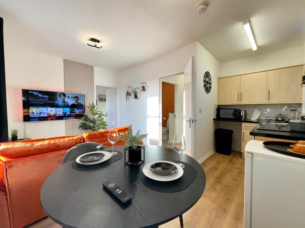 a kitchen and living room with a table and a couch at Rooms Near Me - Apartment 3, Smart Tv, Free Parking in Halesowen