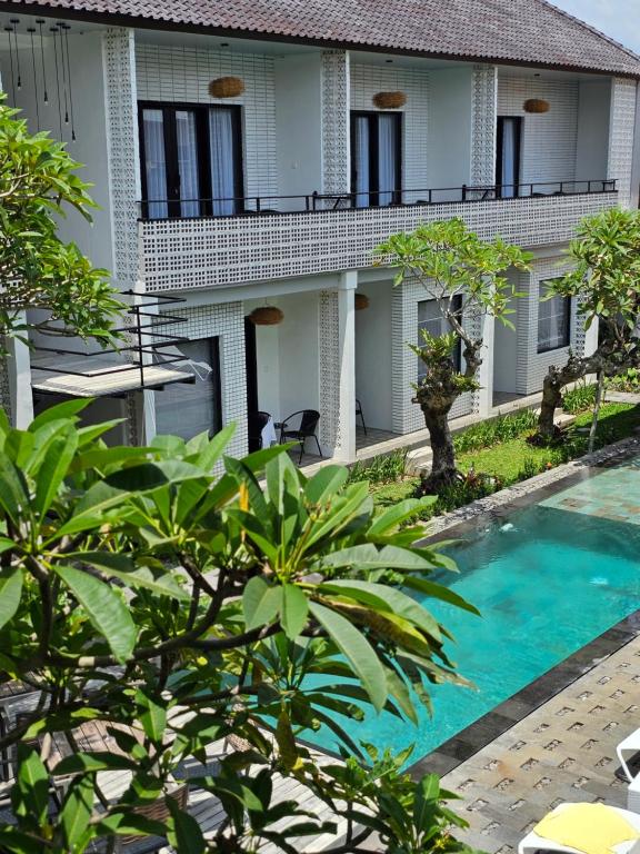 a house with a swimming pool in front of it at Chandi Hotel Ubud in Ubud