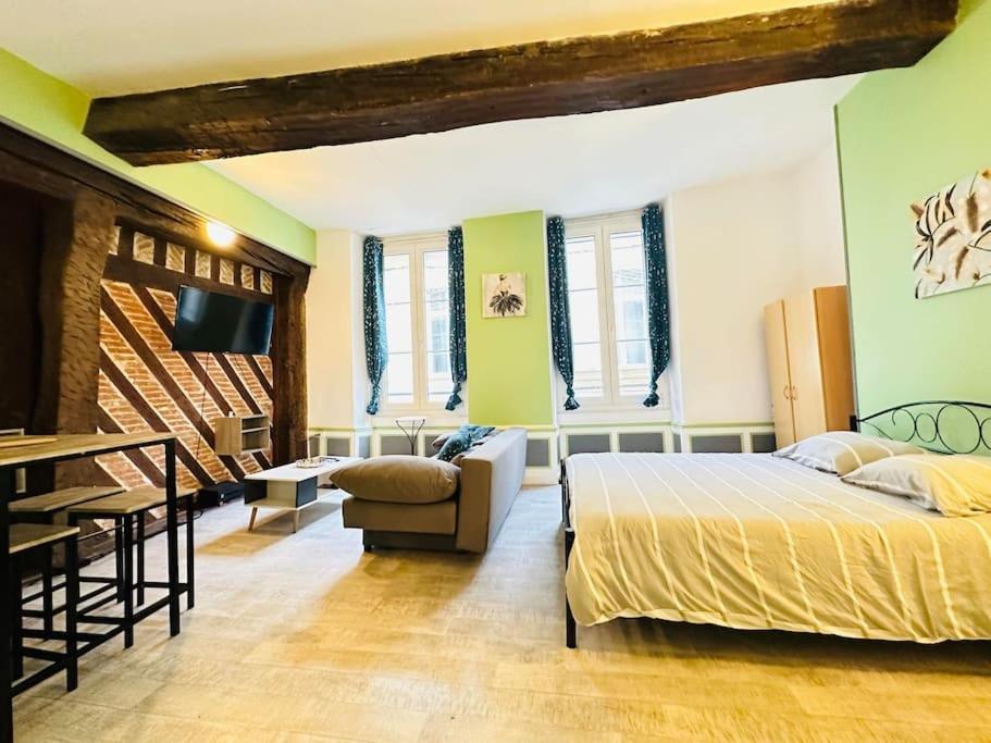 a bedroom with a bed and a couch and a table at Le Havre de Paix in Laon