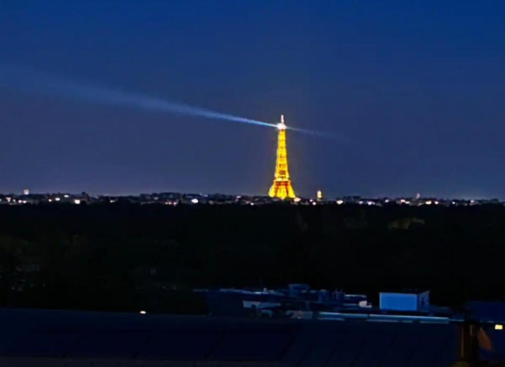 a view of the eiffel tower at night at Maison familiale avec vue tour Eiffel in Suresnes