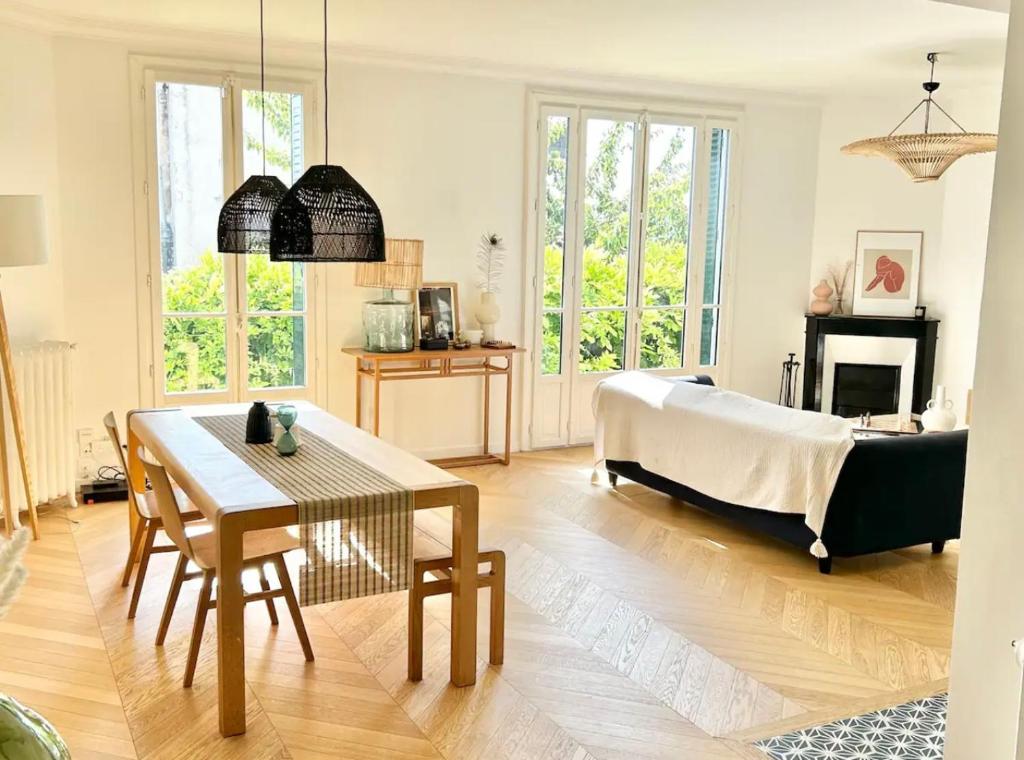 a living room with a bed and a table at Maison familiale avec vue tour Eiffel in Suresnes