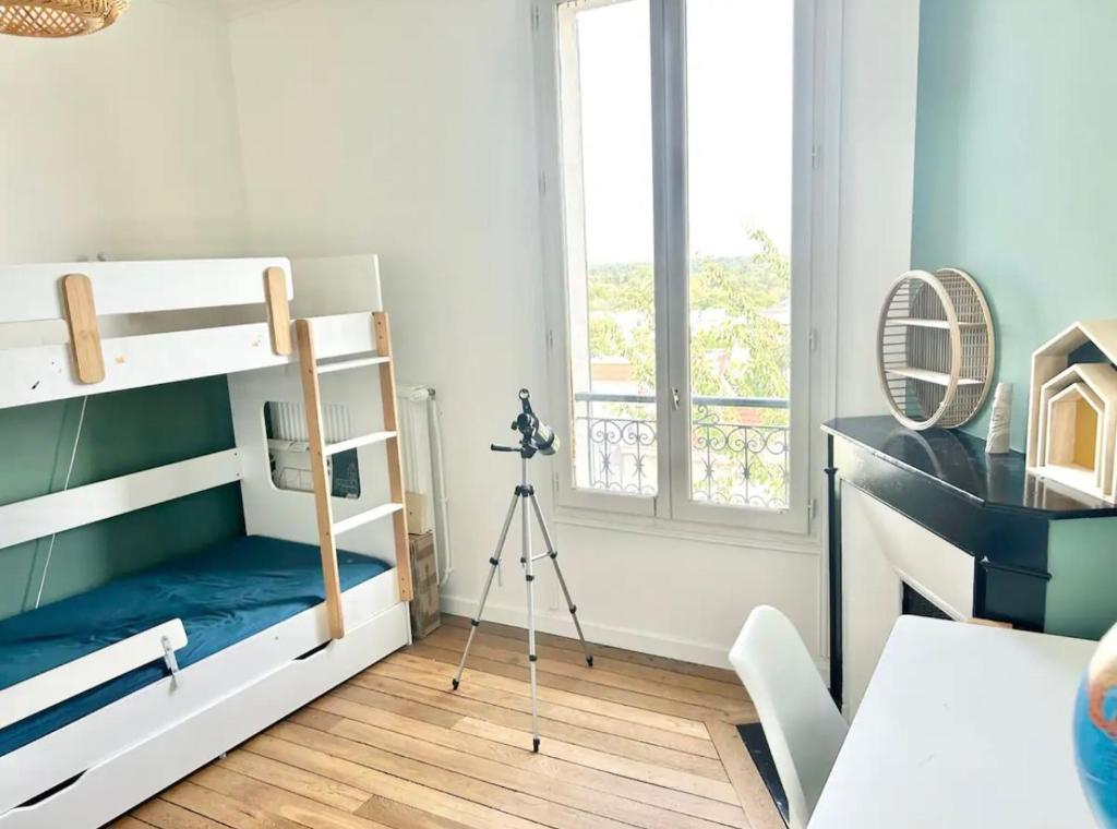 a bedroom with bunk beds and a camera at Maison familiale avec vue tour Eiffel in Suresnes