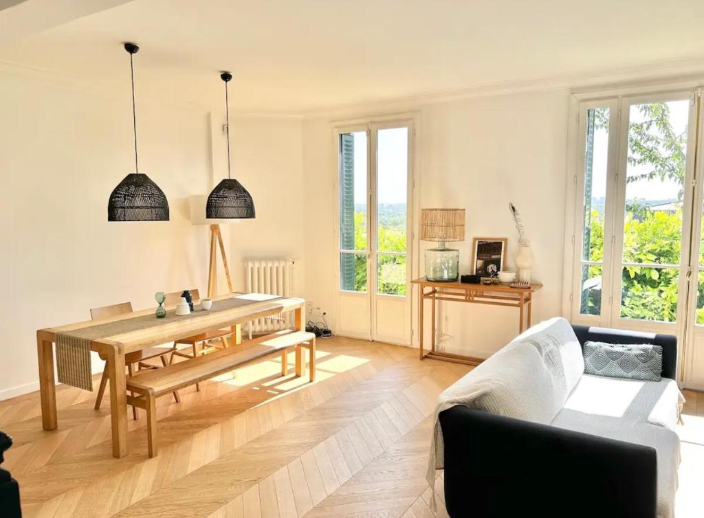 a living room with a table and a couch at Maison familiale avec vue tour Eiffel in Suresnes