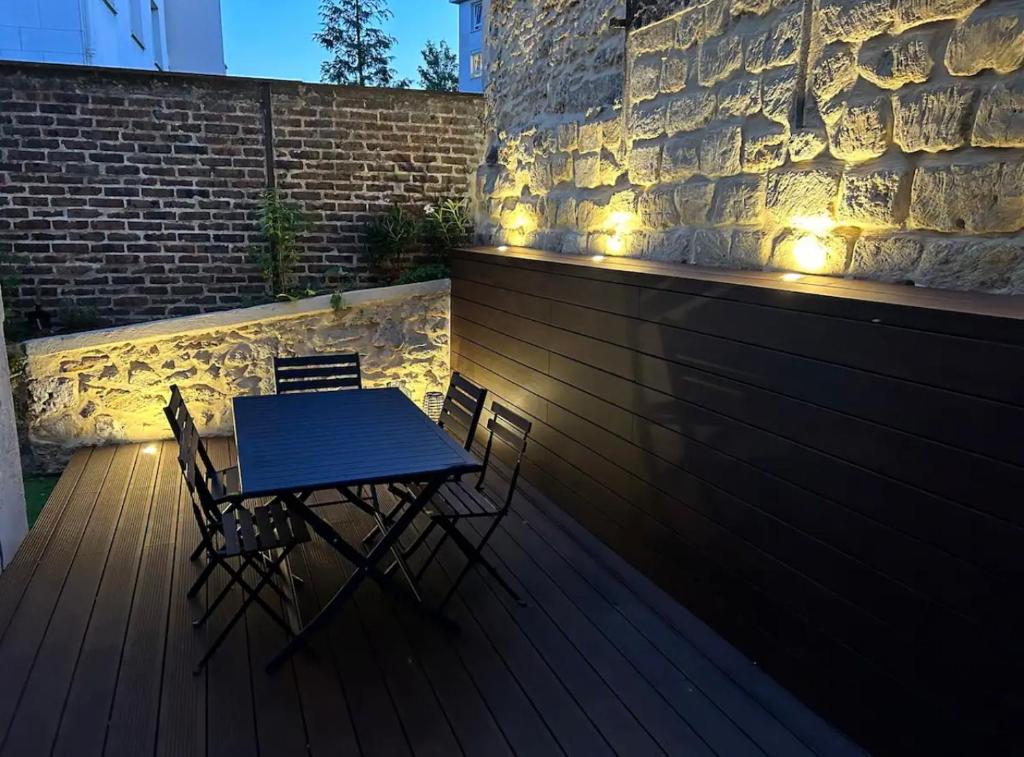 a table and chairs on a deck with lights at Maison familiale avec vue tour Eiffel in Suresnes