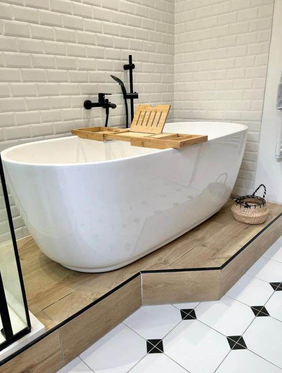 a large white bath tub sitting on top of a floor at Maison familiale avec vue tour Eiffel in Suresnes