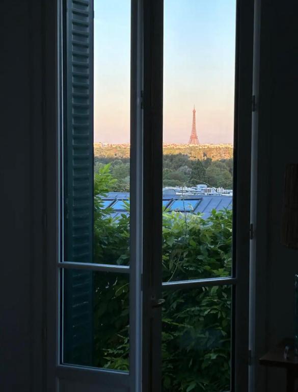 an open window with a view of the eiffel tower at Maison familiale avec vue tour Eiffel in Suresnes