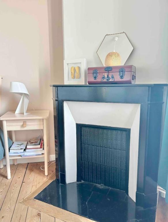 a blue fireplace in a living room with a table at Maison familiale avec vue tour Eiffel in Suresnes