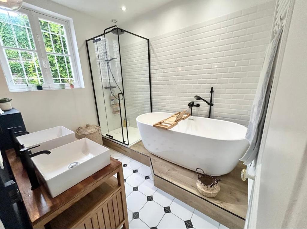a bathroom with a white tub and a sink at Maison familiale avec vue tour Eiffel in Suresnes