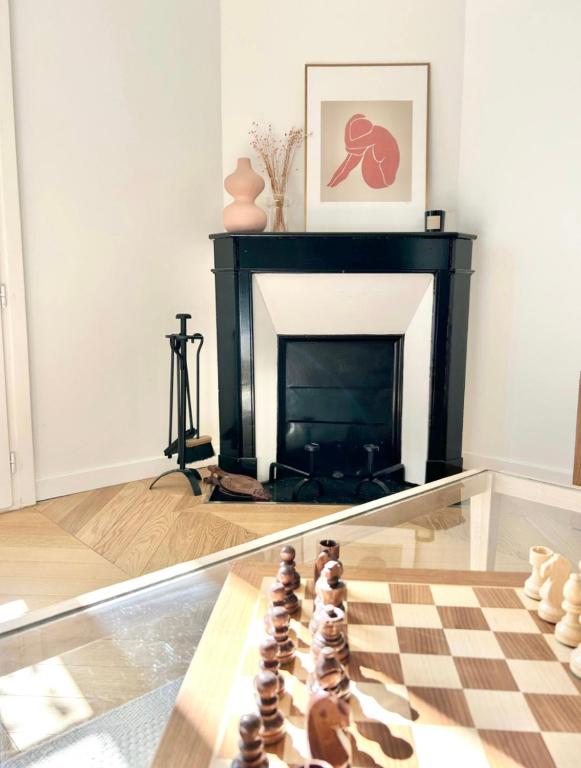 a room with a chess board and a fireplace at Maison familiale avec vue tour Eiffel in Suresnes
