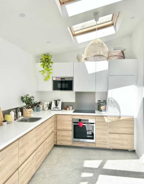 a kitchen with white cabinets and a sink at Maison familiale avec vue tour Eiffel in Suresnes