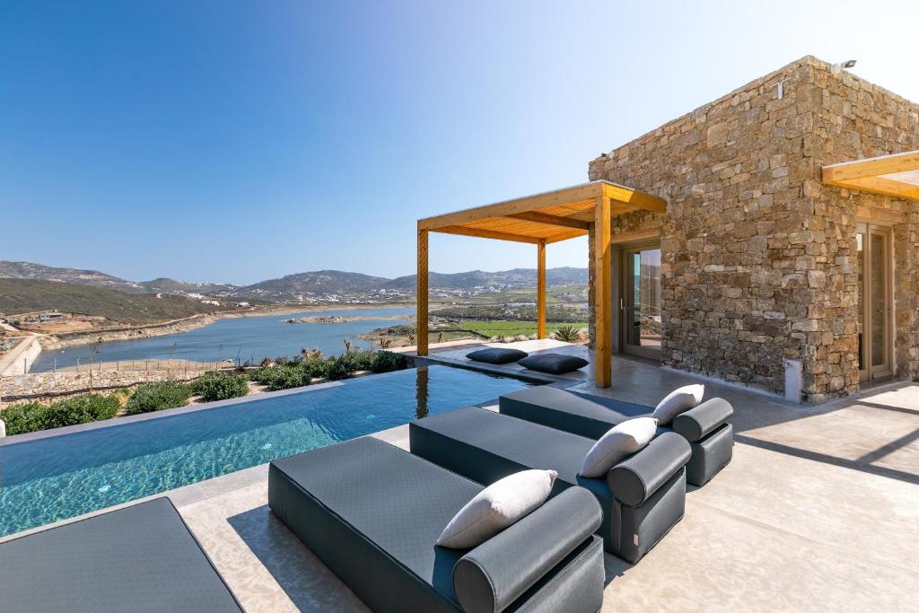 a villa with a swimming pool and a house at Panormos Bay Suites Luxury Resort in Panormos Mykonos