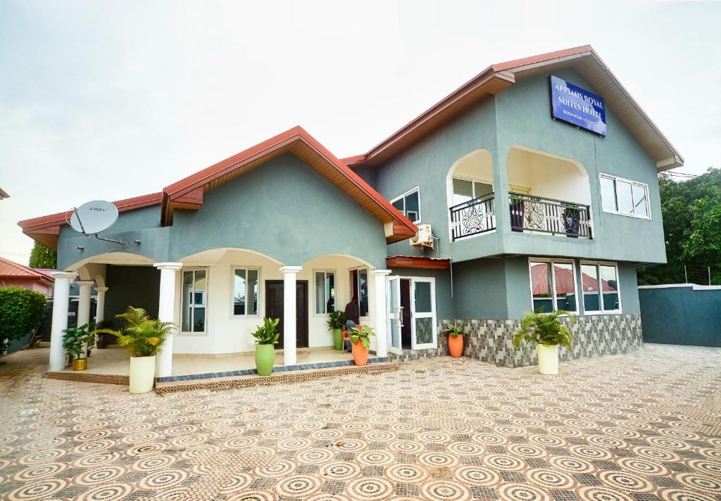 a blue house with a lot of plants in front of it at Appiah's Royal Suites in Accra