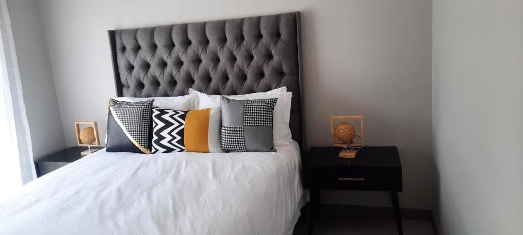 a bedroom with a large bed with pillows on it at 15 Elizabeth Place - Luxury Apartments, Free Wi-Fi in Midrand