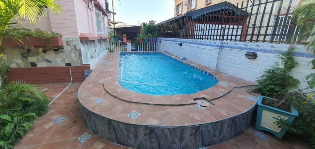 a swimming pool in front of a house at Kaya Lethu in Maputo