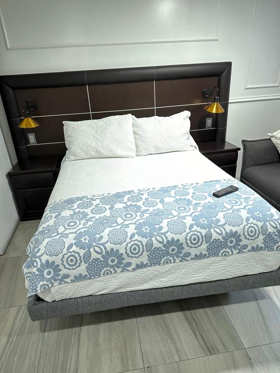 1 dormitorio con 1 cama con manta azul y blanca en Villa GyG, en Ciudad de México