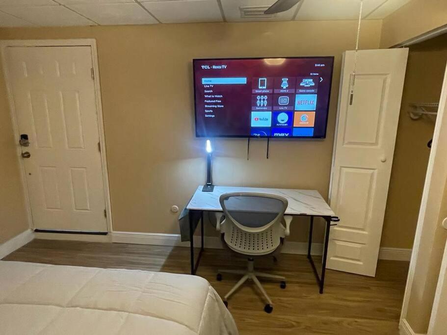 a bedroom with a desk and a tv on the wall at Unforgettable Stay in Orlando 1 in Orlando