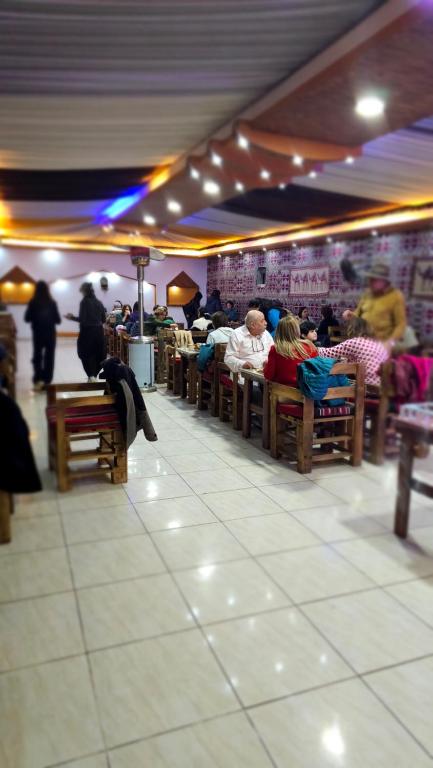 a group of people sitting on benches in a restaurant at orbit camp 2 in Wadi Rum