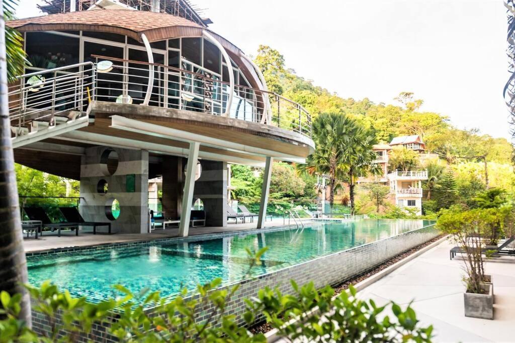 a building with a swimming pool with a balcony at Private apartment at Emerald Terrace in Patong Beach