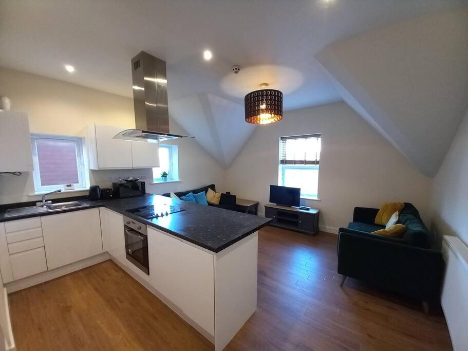uma cozinha e uma sala de estar com uma bancada em Roomy Penthouse 2 double bed apartment - Spacious - Central Beeston - Free secure parking - em Nottingham