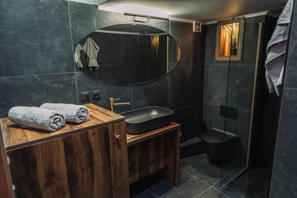 uma casa de banho com um lavatório e um chuveiro com um espelho. em INDIVIDUALliving 1 em Tessalónica