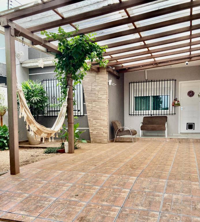 a pergola with a hammock on a patio at Casa centro Falls in Foz do Iguaçu