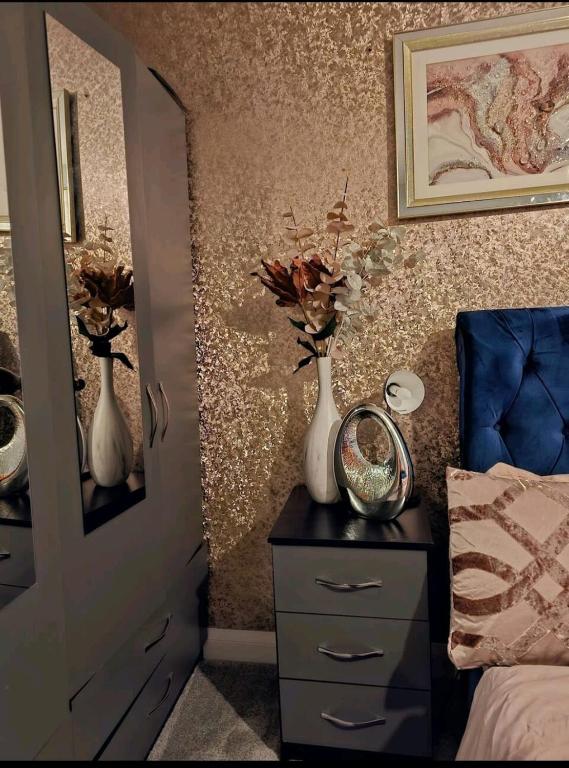 a bedroom with two vases on a dresser and a mirror at Angle’s Nest in Whitchurch