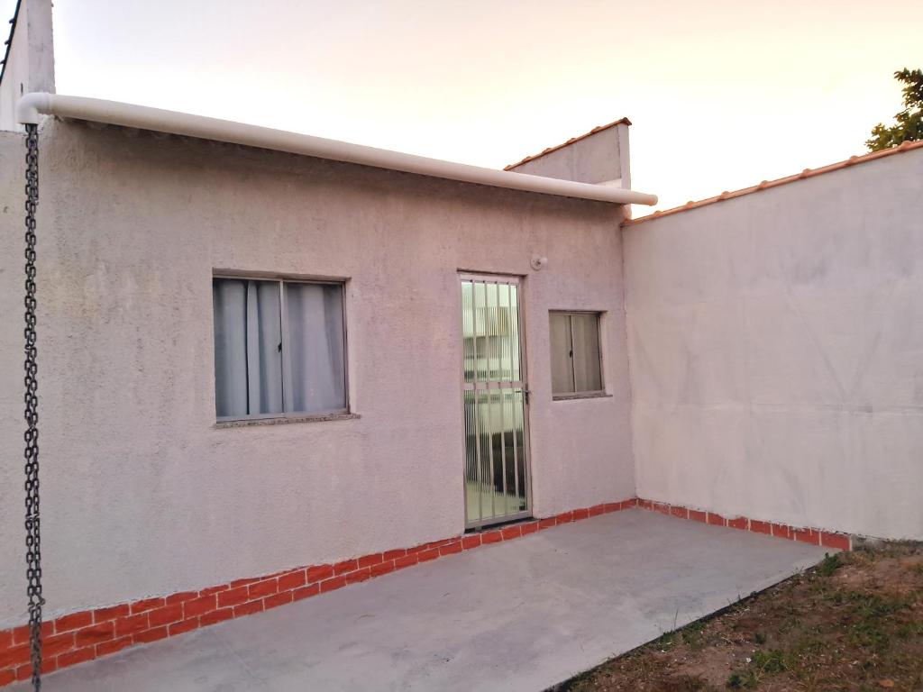 a white building with two windows on the side of it at Mini Casa Aconchegante in Saquarema