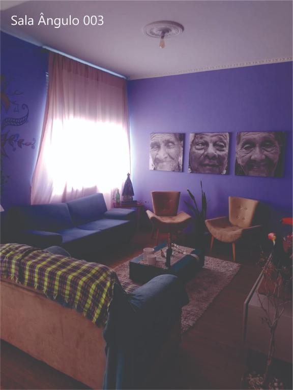 a living room with a couch and portraits of men at Quarto Carnaval 2024 Salvador in Salvador