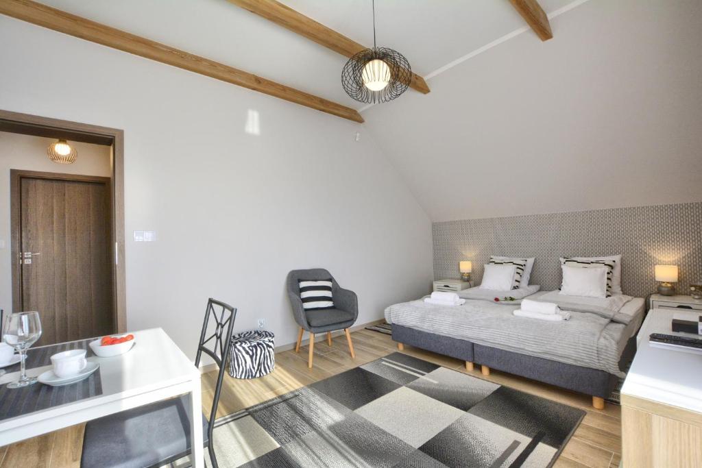 Un dormitorio con una cama y una silla en una habitación. en Willa Widokówka Lubawka, en Lubawka