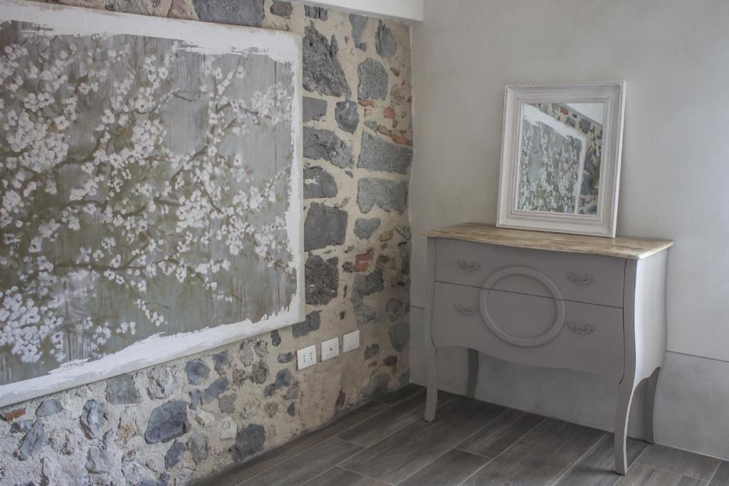 a bathroom with a stone wall and a washing machine at Le Dolcezze in Crone