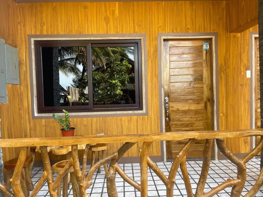 a wooden bench in front of a building with a window at Siquijor Plage Inn in Siquijor