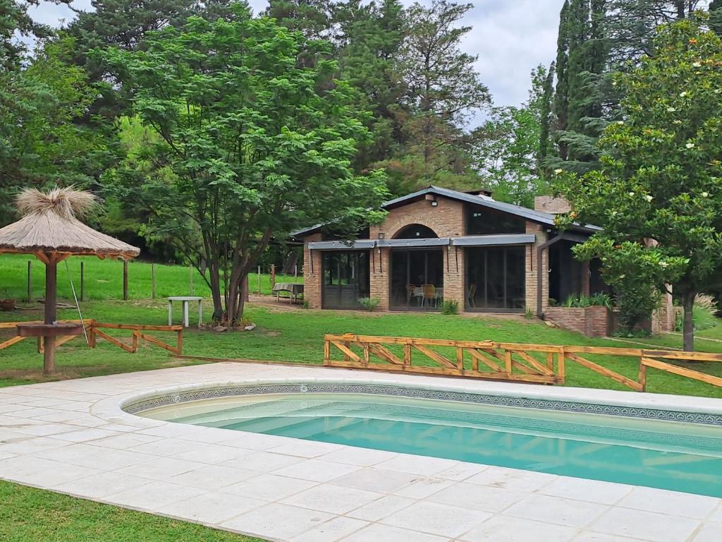 una piscina en un patio con una casa en La Calma, casa frente al río, gran parque y pileta en Villa Icho Cruz