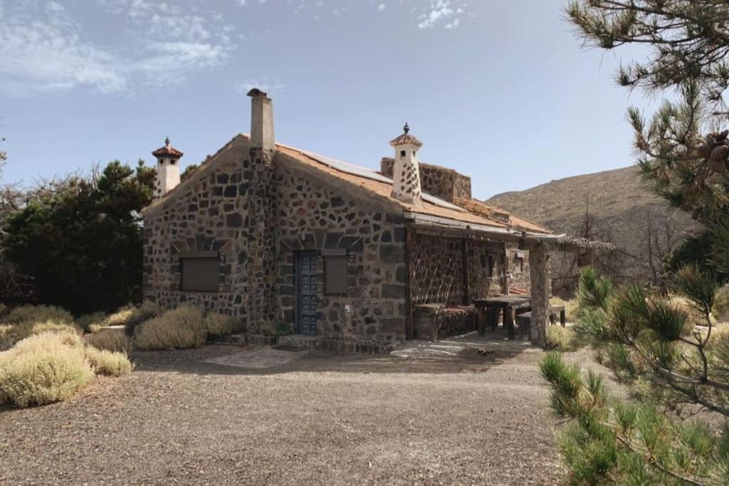 an old stone house with a mountain in the background at La Casa del Teide, d-espacios in La Orotava