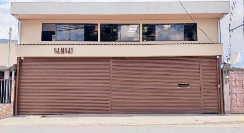 una grande porta del garage sul lato di un edificio di Apartamento SamSay I a Cartago